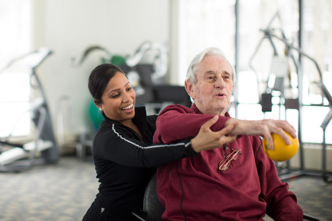 physical therapist working with elderly man